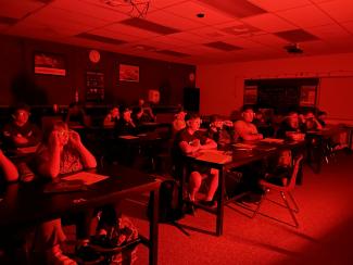 Students in a red backlit room